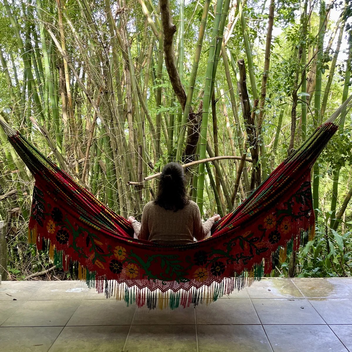 Woman relaxing in hammock surrounded by rainforest at Dos Aguas B&B during Root to Rise Retreat in Puerto Rico