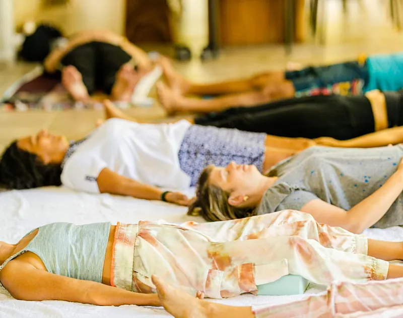Guests resting in sabasana pose during restorative yoga class at Dos Aguas Retreat