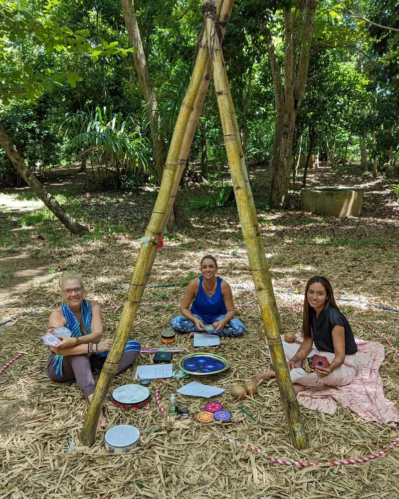 Retreat group sitting under bamboo structure outdoors at Dos Aguas Retreat