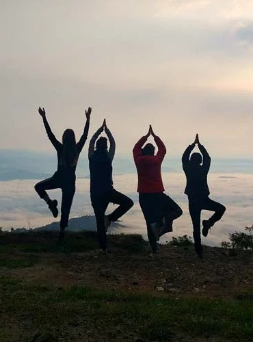 Group Trip Group practicing yoga poses outdoors at sunrise — mindful adventure retreats in Puerto Rico with yoga, meditation, and cultural immersion